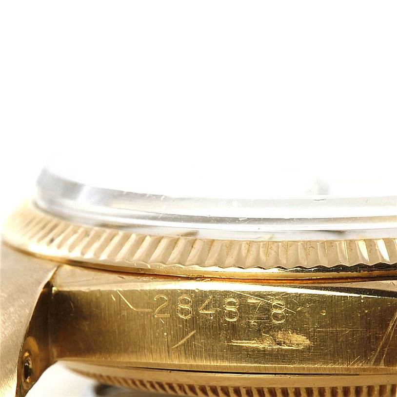 This close-up image shows the side of the gold case and fluted bezel of the Rolex Vintage Collection 6605 Men's Yellow Gold Silver Dial 6605 Men's Yellow Gold Silver Dial watch, along with its serial number.