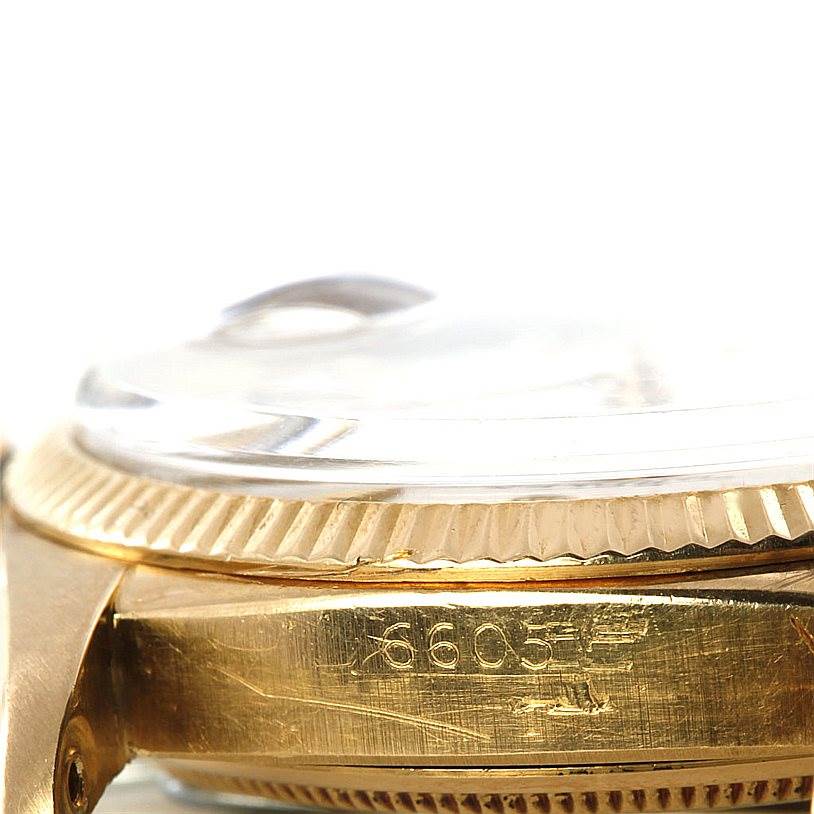 This close-up image shows the side of the Rolex Vintage Collection 6605 Men's Yellow Gold Silver Dial 6605 Men's Yellow Gold Silver Dial watch, focusing on the bezel, crystal, and part of the case with engraved numbers.