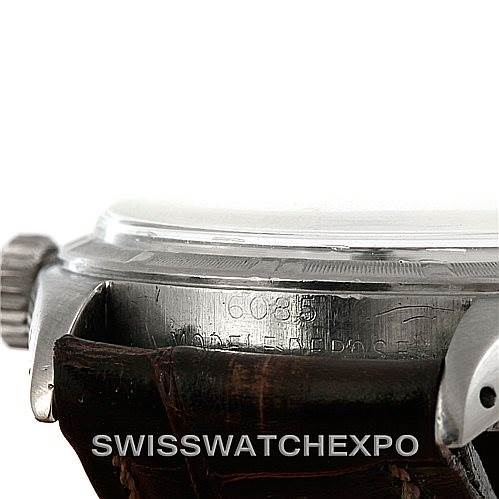 The image shows a side angle of a Rolex Vintage Collection 6085 Men's Stainless Steel Silver Dial 6085 Men's Stainless Steel Silver Dial watch, focusing on the crown and engraved case details.