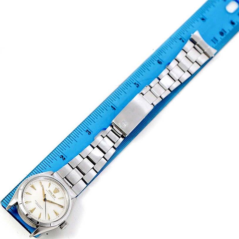 The Rolex Vintage Collection 6285 Men's Stainless Steel Silver Dial 6285 Men's Stainless Steel Silver Dial watch is shown from a top-down angle, displaying the face and full metal bracelet next to a ruler.