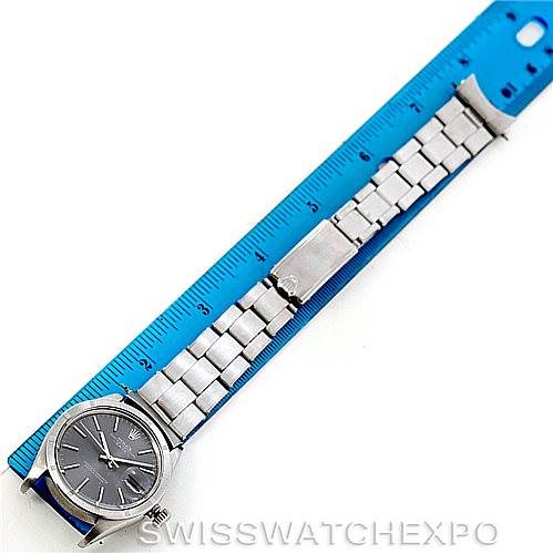 This image shows a top-down view of a Rolex Vintage Collection 1501 Men's Stainless Steel Grey Dial 1501 Men's Stainless Steel Grey Dial watch with its stainless steel bracelet laid next to a ruler for scale.