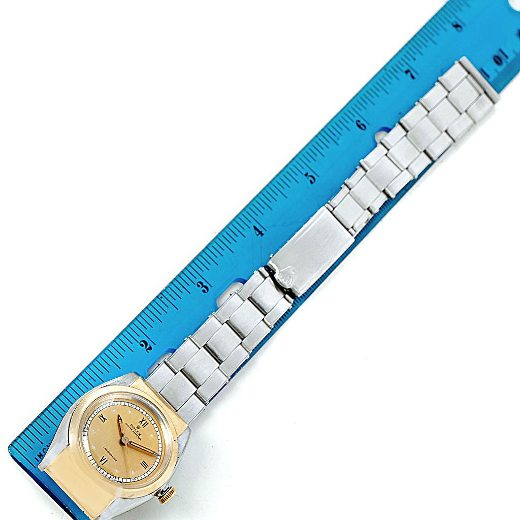 This image shows a Rolex Vintage Collection 3065 Men's Steel and Gold (two tone) Champagne Dial 3065 Men's Steel and Gold (two tone) Champagne Dial watch laid flat with its bracelet next to a blue ruler for scale.