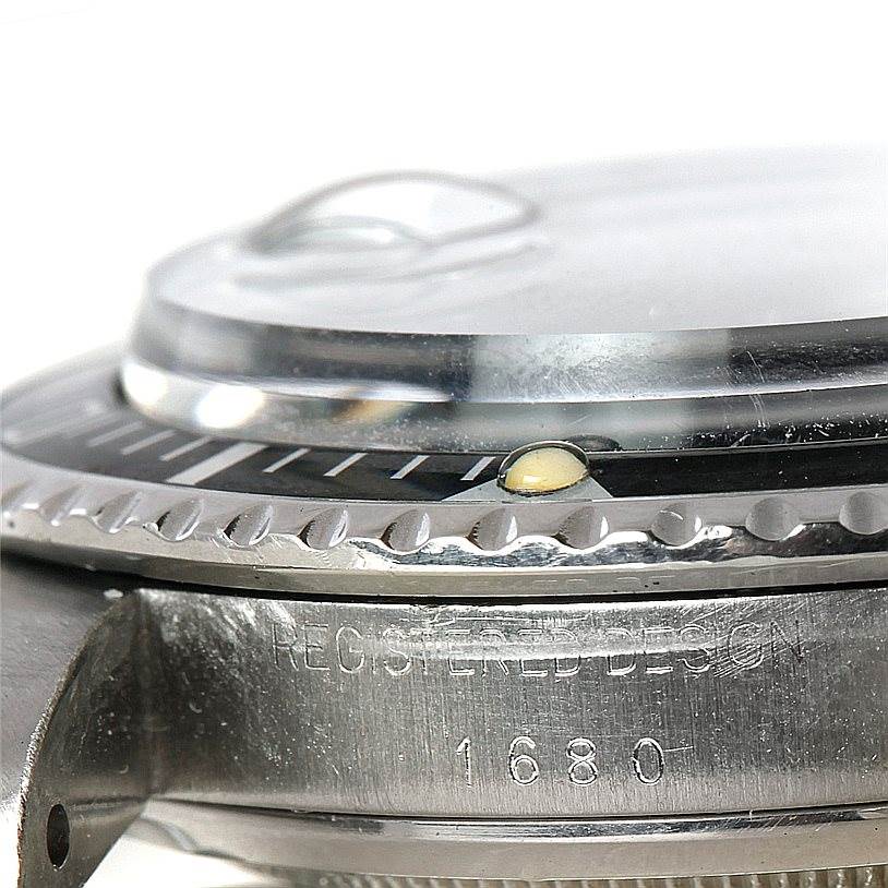 This close-up side view of the Rolex Vintage Collection 1680 Men's Stainless Steel Black Dial 1680 Men's Stainless Steel Black Dial 1680 model shows the bezel, crystal, and part of the case.