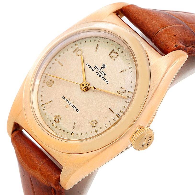 The Vintage Collection Rolex watch is shown from a three-quarter angle, highlighting its face, bezel, and crown, with a brown leather strap.