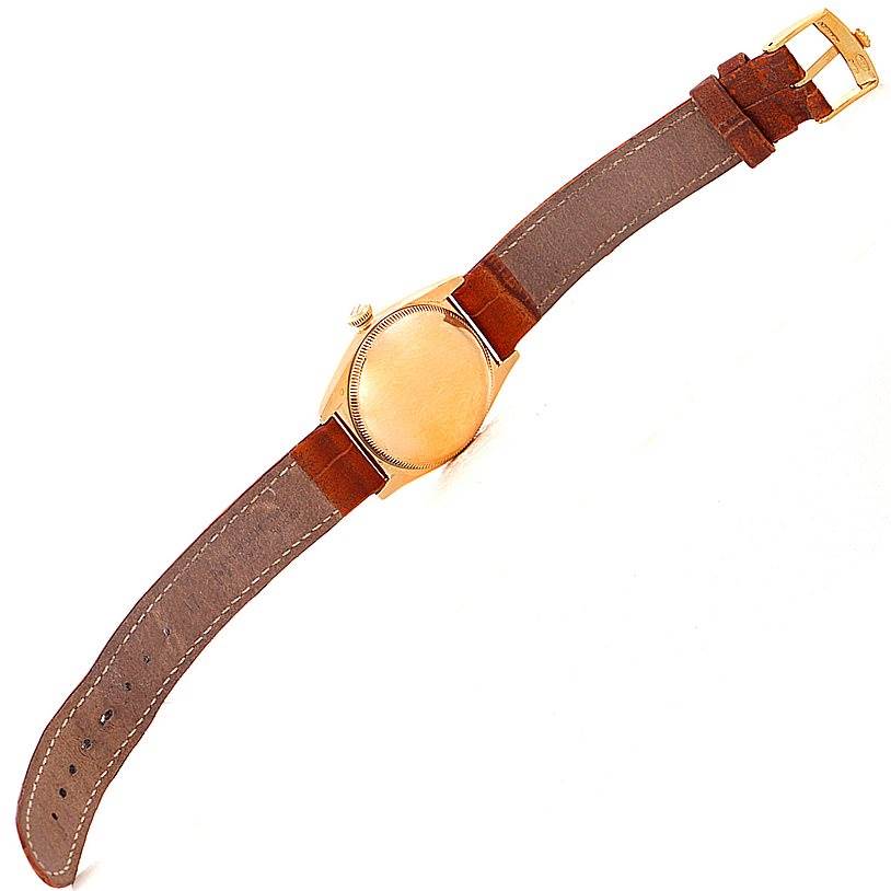 This image shows the back view of the Rolex Vintage Collection 3131 Men's Yellow Gold Silver Dial 3131 Men's Yellow Gold Silver Dial watch with its brown leather strap and gold-tone case.