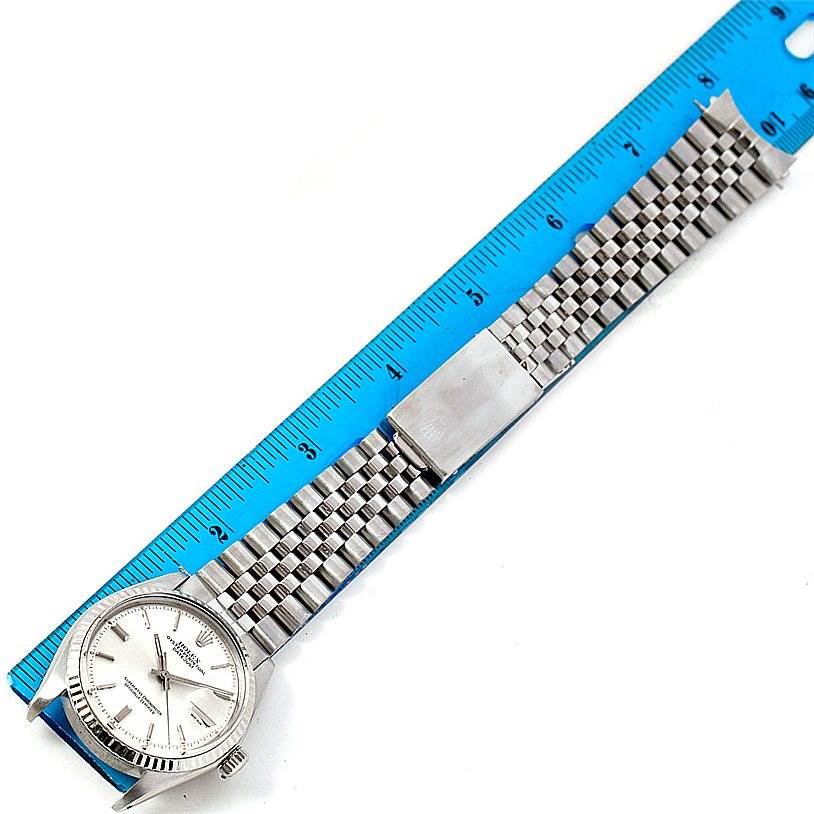 The Rolex Vintage Collection 1601 Men's Stainless Steel Silver Dial 1601 Men's Stainless Steel Silver Dial model features a silver dial and a stainless steel bracelet, shown laid flat alongside a ruler.