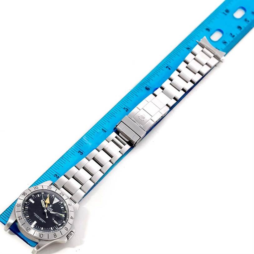 This image shows a top-down view of a Rolex Vintage Collection 1655 Men's Stainless Steel Black Dial 1655 Men's Stainless Steel Black Dial model, displaying its face, bezel, and metal bracelet aligned with a blue ruler.