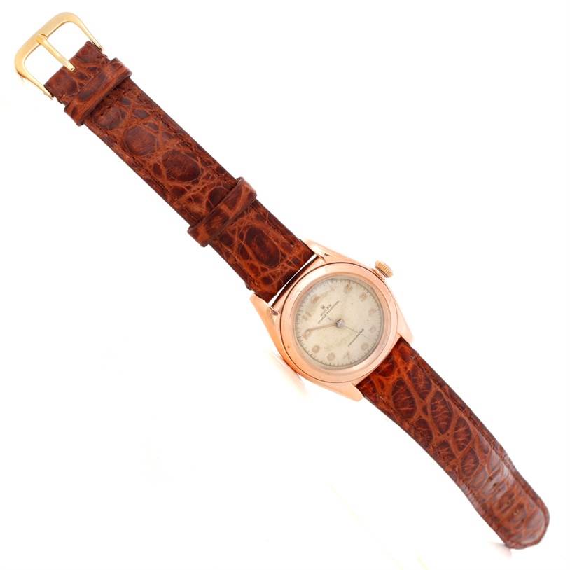 The image features a Rolex Vintage Collection 3131 Men's Rose Gold Silver Dial 3131 Men's Rose Gold Silver Dial watch angled diagonally, showcasing its brown leather strap and round dial.