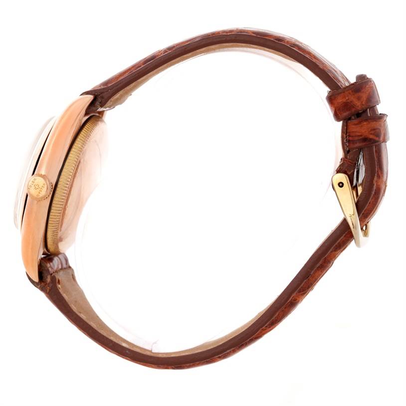 This side view of the Rolex Vintage Collection 3131 Men's Rose Gold Silver Dial 3131 Men's Rose Gold Silver Dial watch shows the leather strap, case, crown, and buckle.