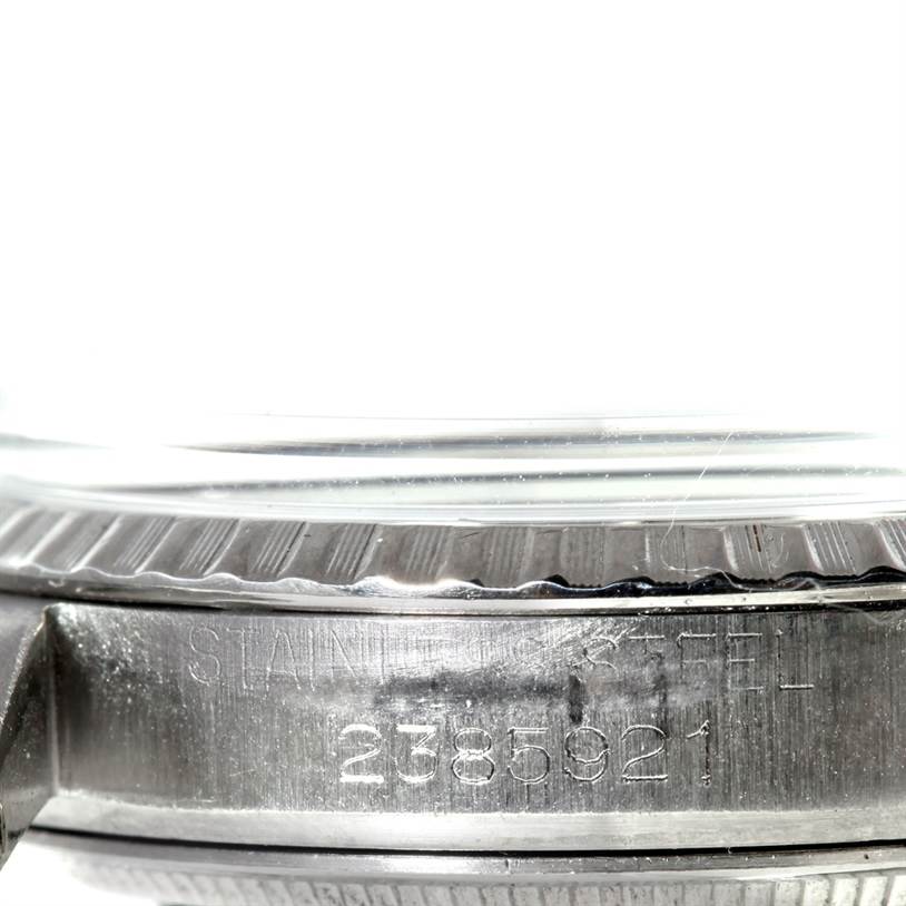 This image shows an extreme close-up of the side of a Rolex Vintage Collection 1603 Men's Stainless Steel Silver Dial 1603 Men's Stainless Steel Silver Dial watch, focusing on the serial number and 'stainless steel' engraving.