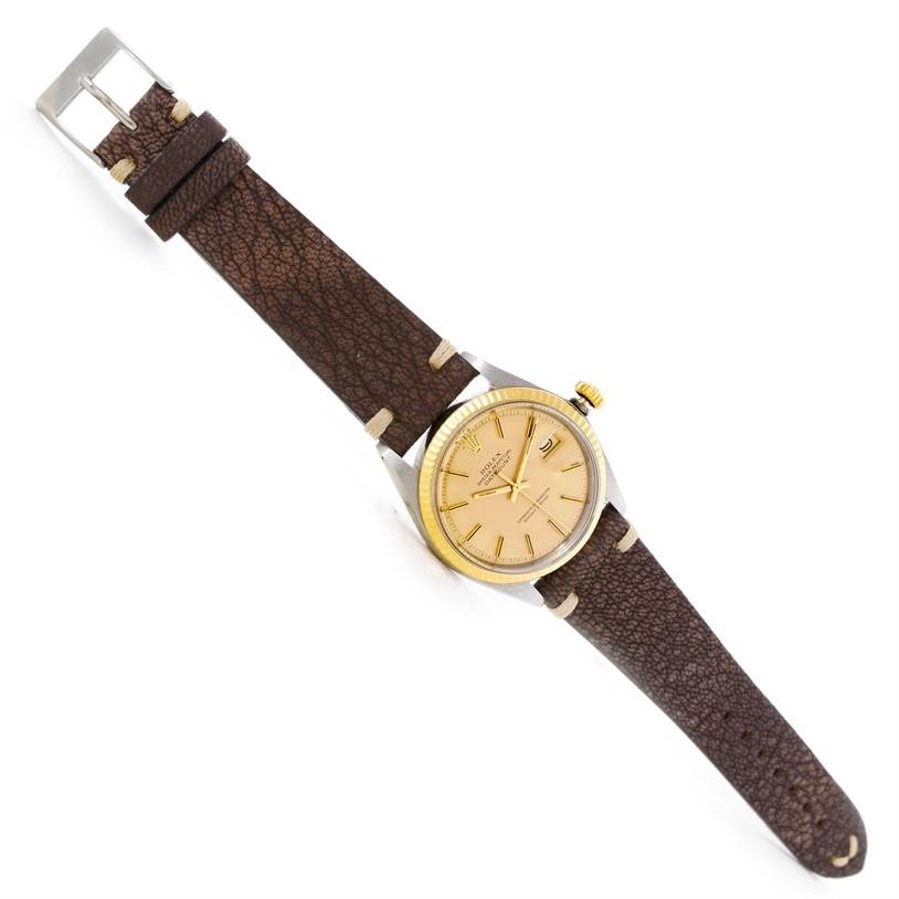 This image shows a Rolex Vintage Collection 1601 Men's Stainless Steel Champagne Dial 1601 Men's Stainless Steel Champagne Dial watch with a gold bezel, brown leather strap, and light-colored dial, captured from a top-down angle.