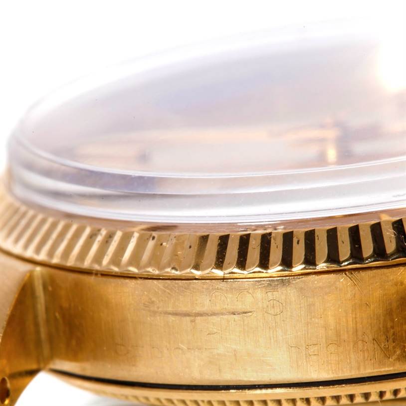 This close-up of the Rolex Vintage Collection 1005 Men's Yellow Gold Champagne Dial 1005 Men's Yellow Gold Champagne Dial watch shows the edge of the case, the crystal, and the fluted bezel from a side angle.