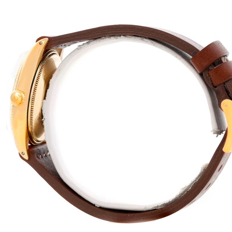 A side view of the Vintage Collection Rolex watch showcases the crown, case, and brown leather strap.