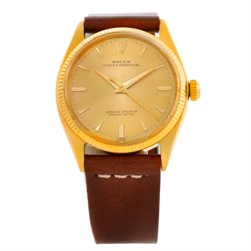 The image shows a top-down view of the Rolex Oyster Perpetual Vintage Collection watch with a gold case and brown leather strap.