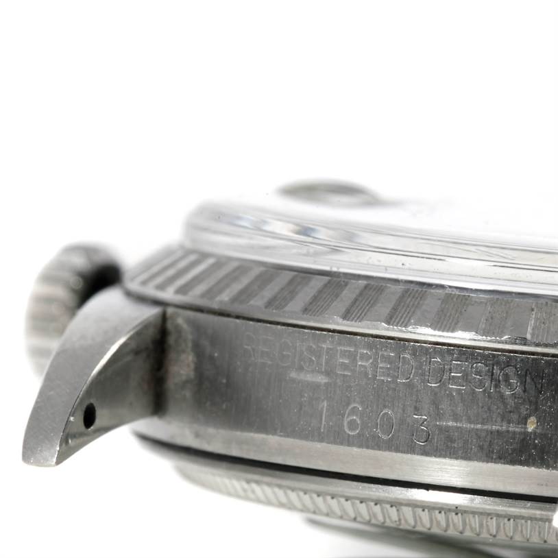 The image shows a close-up side view of the Rolex Vintage Collection 1603 Men's Stainless Steel Grey Dial 1603 Men's Stainless Steel Grey Dial model, focusing on the crown, bezel, and case with "Registered Design" markings.
