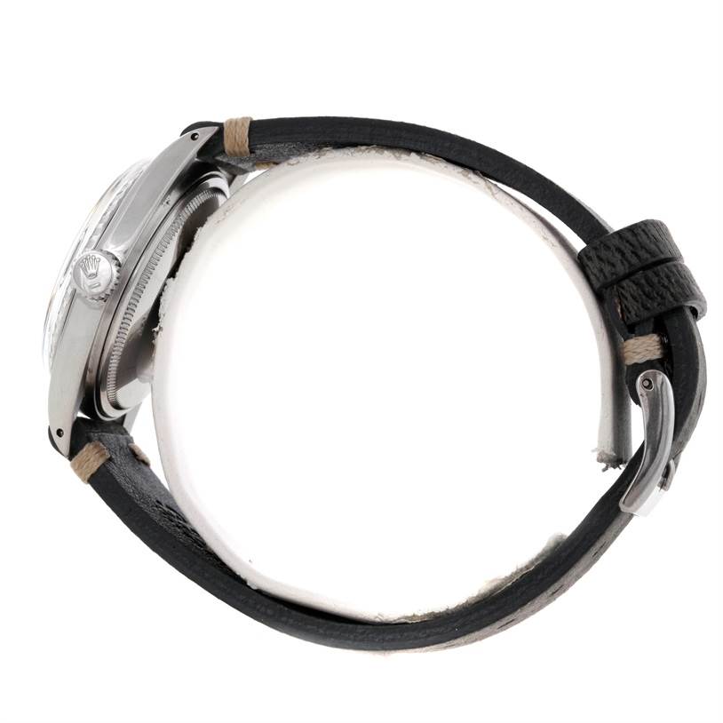 This side view of the Rolex Vintage Collection 1603 Men's Stainless Steel Grey Dial 1603 Men's Stainless Steel Grey Dial watch shows the case, crown, bezel, and leather strap with buckle.