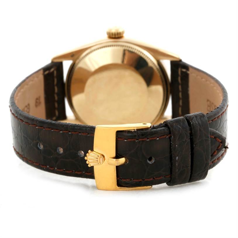 The image shows the back of the Vintage Collection Rolex watch, focusing on its gold case and black leather strap with a gold buckle.