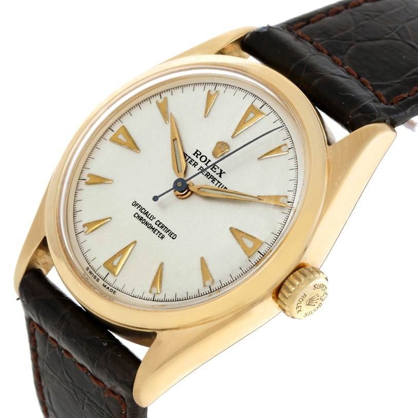 This Rolex Vintage Collection 6084 Men's Yellow Gold Silver Dial 6084 Men's Yellow Gold Silver Dial model is shown from a high-angle view, displaying the dial, crown, and part of the leather strap.