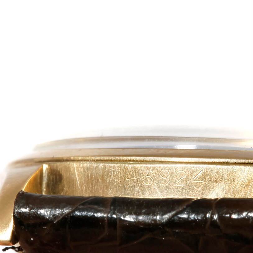 The image shows a close-up of the side of the Rolex Vintage Collection 6084 Men's Yellow Gold Silver Dial 6084 Men's Yellow Gold Silver Dial watch, focusing on the engraved model number and leather strap.