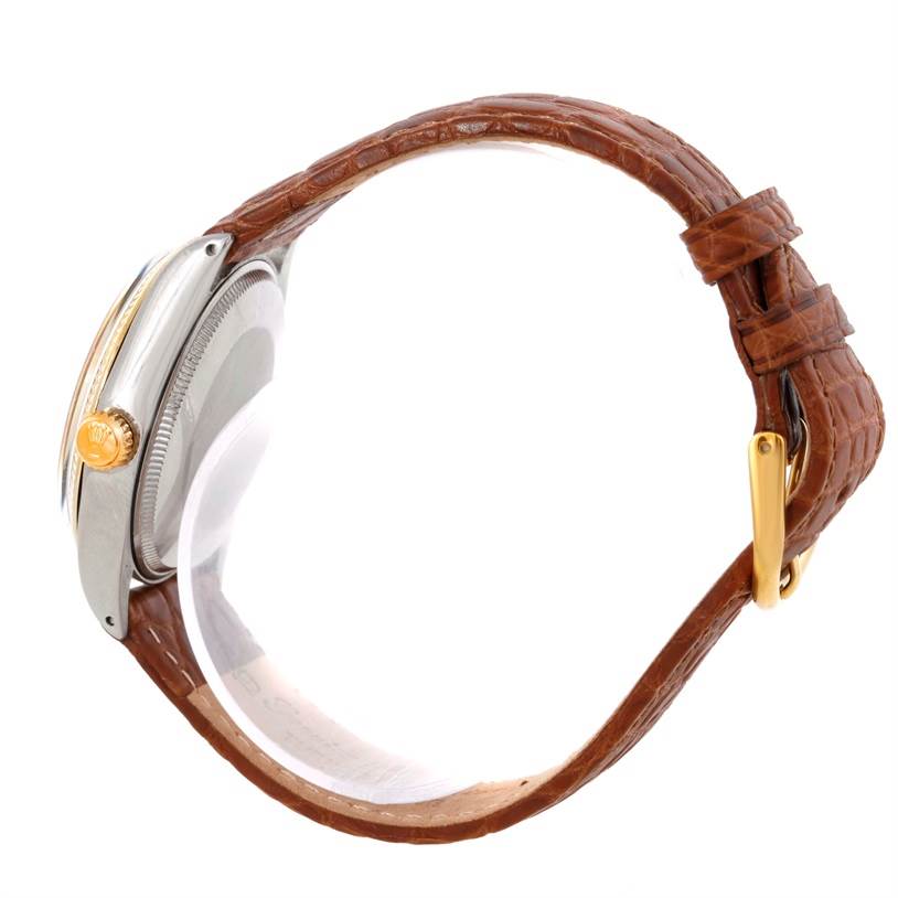 This image shows a side view of a Rolex Vintage Collection 5501 Men's Steel and Gold (two tone) Silver Dial 5501 Men's Steel and Gold (two tone) Silver Dial watch with a brown leather strap and gold crown.