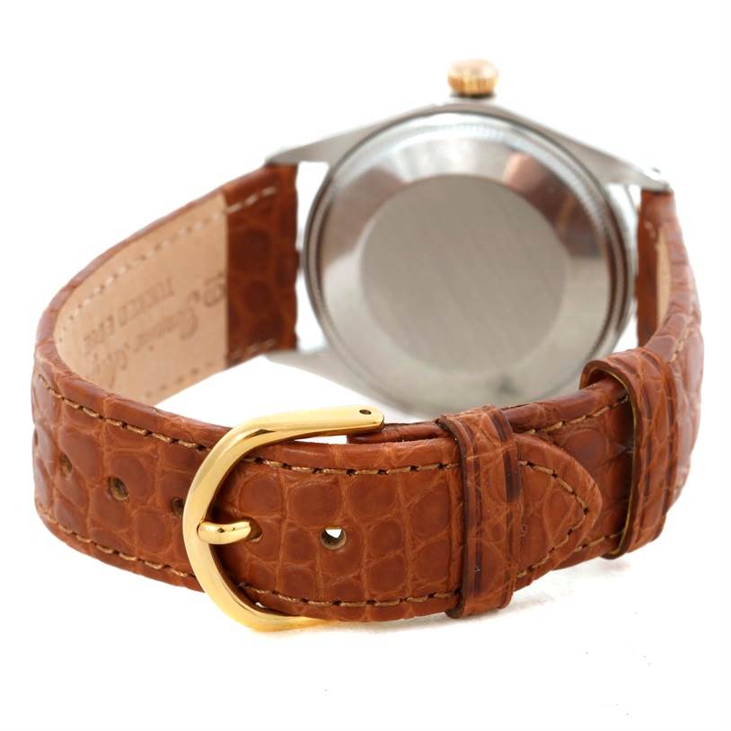 The image shows the Vintage Collection Rolex watch from the back, highlighting its case back and brown leather strap with a gold buckle.