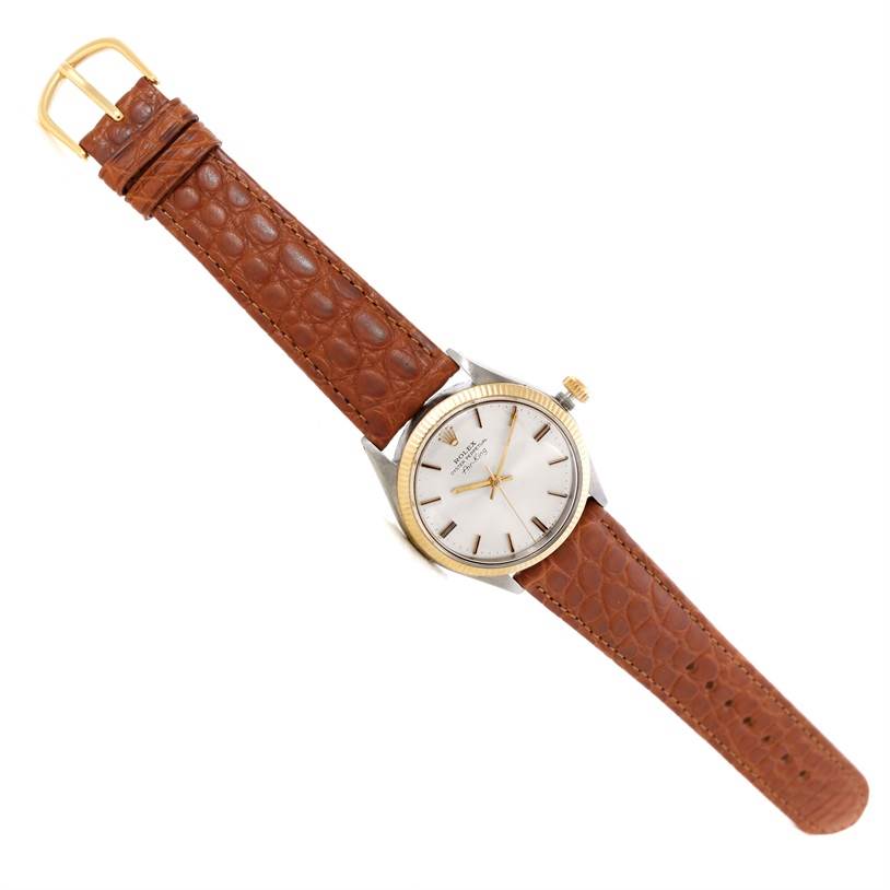 This Rolex Vintage Collection 5501 Men's Steel and Gold (two tone) Silver Dial 5501 Men's Steel and Gold (two tone) Silver Dial model is shown from a top-down angle, displaying the entire watch including the face, bezel, and leather strap.