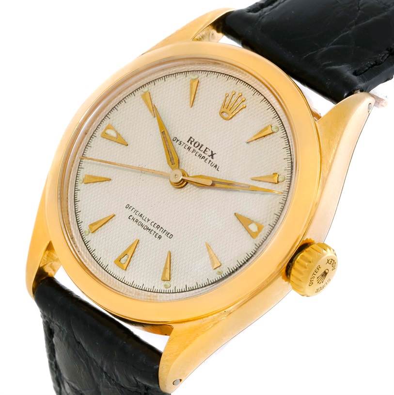 The image shows a close-up angle of the Rolex Vintage Collection 6084 Men's Yellow Gold Silver Dial 6084 Men's Yellow Gold Silver Dial watch, highlighting its dial, crown, case, and black leather strap.