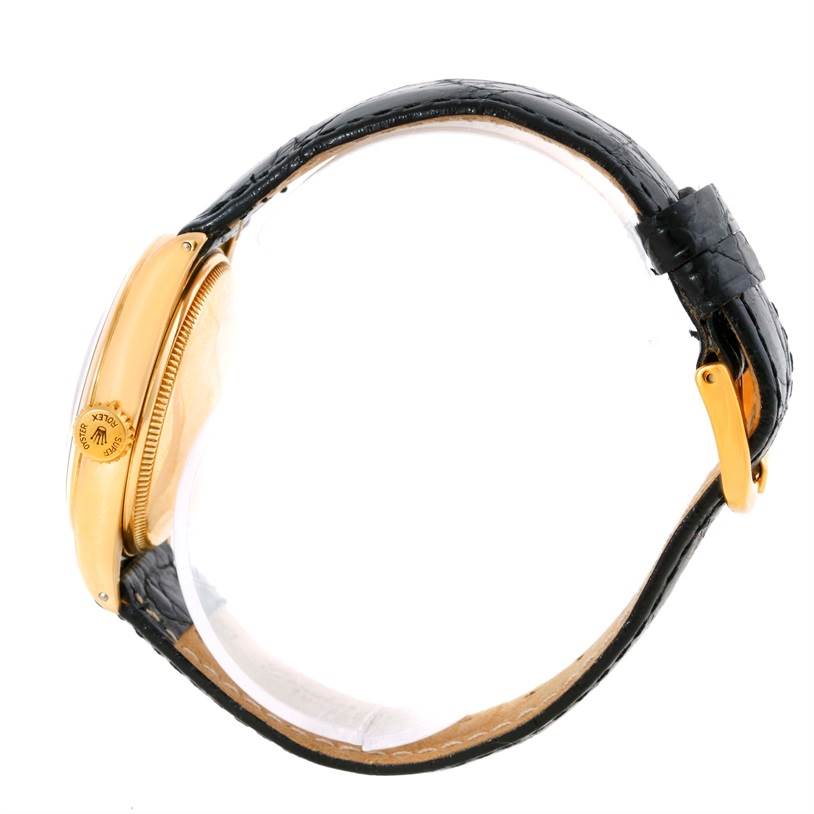 The side view of the Rolex Vintage Collection 6084 Men's Yellow Gold Silver Dial 6084 Men's Yellow Gold Silver Dial model watch displays the crown, case, and part of the leather strap.