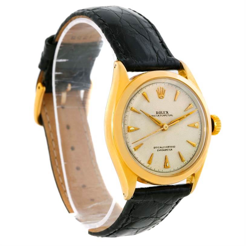 The Rolex Vintage Collection 6084 Men's Yellow Gold Silver Dial 6084 Men's Yellow Gold Silver Dial watch is shown at a slight side angle, displaying the face, bezel, crown, and leather strap.