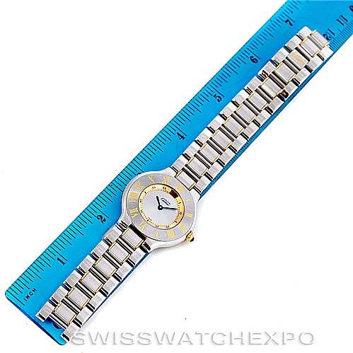 The Cartier Must 21 W10073R6 Men's Stainless Steel Silver Dial W10073R6 Men's Stainless Steel Silver Dial watch is shown from an overhead angle, highlighting its face, bezel, and bracelet next to a ruler for scale.