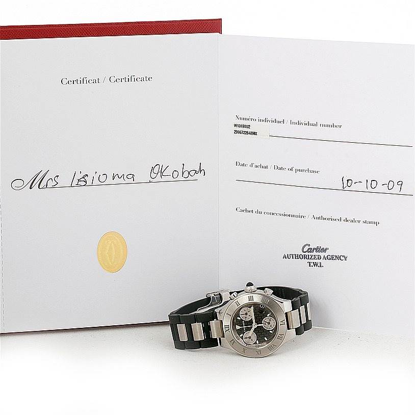 The image shows a Cartier Must 21 W10198U2 Women's Stainless Steel Black Dial W10198U2 Women's Stainless Steel Black Dial watch with its certificate, lying flat on a surface, alongside an open certificate booklet.