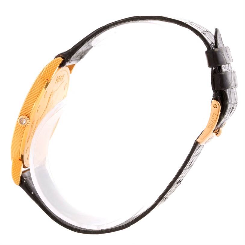 The image shows a side view of a Corum Coin Watch 4414556 Men
s Yellow Gold Black Dial 4414556 Men
s Yellow Gold Black Dial model, displaying the gold case and leather strap.