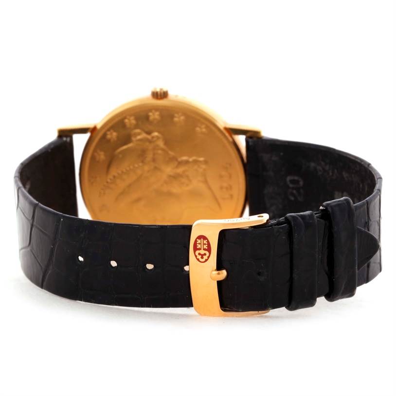 The image shows the back view of a Corum Coin Watch 4414556 Men
s Yellow Gold Black Dial 4414556 Men
s Yellow Gold Black Dial, focusing on the golden coin case and black leather strap with a gold buckle.