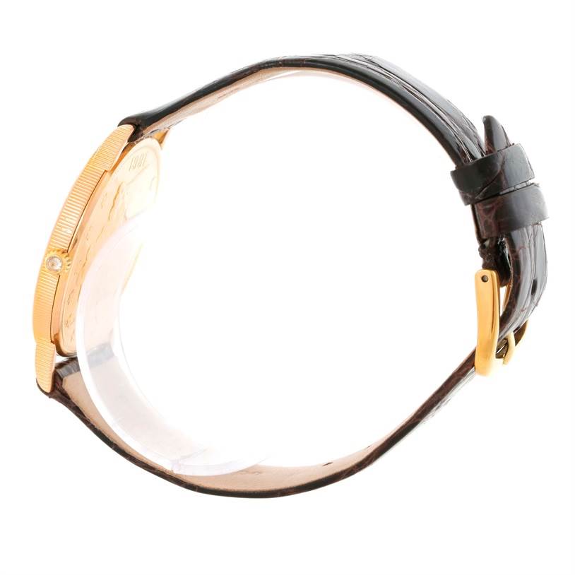 The image shows a side view of the Corum Coin Watch Men's Yellow Gold Black Dial Men's Yellow Gold Black Dial model, highlighting its case, crown, and part of the strap with the buckle.