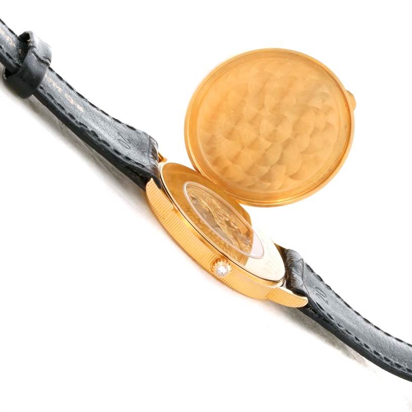 The image shows a side angle of the Corum Coin Watch Men's Yellow Gold Black Dial Men's Yellow Gold Black Dial model, focusing on the watch's case, crown, and partially open case cover.