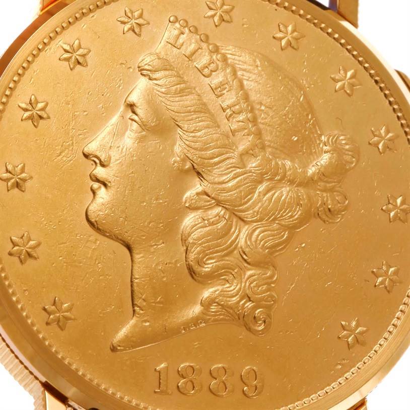 The image shows a close-up of the face of the Corum Coin Watch Men's Yellow Gold Black Dial Men's Yellow Gold Black Dial model, featuring a coin with a profile design and the year 1889.