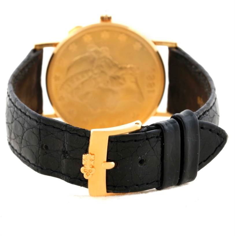 The image shows the back angle of a Corum Coin Watch Men's Yellow Gold Black Dial Men's Yellow Gold Black Dial model, featuring its black leather strap and gold buckle clasp.