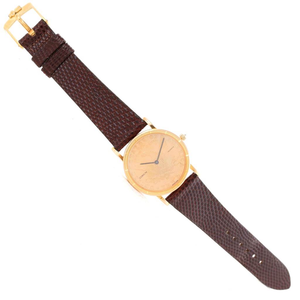The image shows a top-down view of the Corum Women's Yellow Gold Black Dial Women's Yellow Gold Black Dial 18K Yellow Gold 10 Dollars Coin Diamond Ladies Watch with brown leather strap.