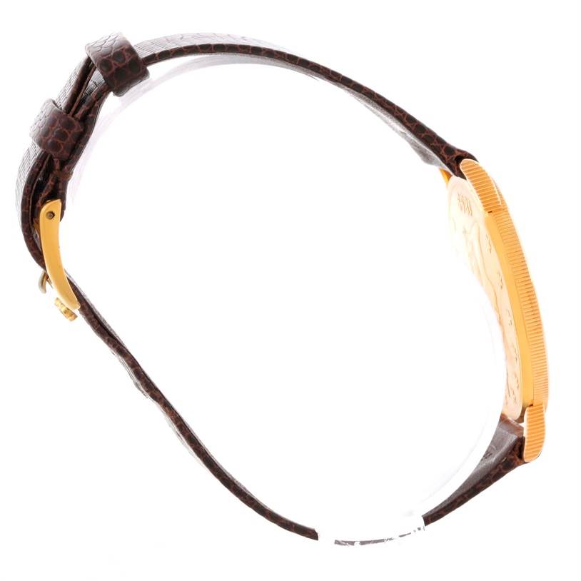 This side view of the Corum Yellow Gold Black Dial Yellow Gold Black Dial 20 Dollars Double Eagle Yellow Gold Coin Brown Strap Watch shows the strap, buckle, and coin-shaped watch case.