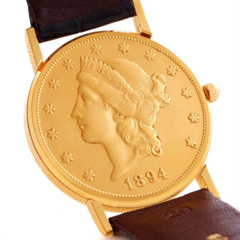 The image shows the case back of a Corum Coin Watch Men's Yellow Gold Black Dial Men's Yellow Gold Black Dial model from a slightly angled view, highlighting its coin design and leather strap attachments.