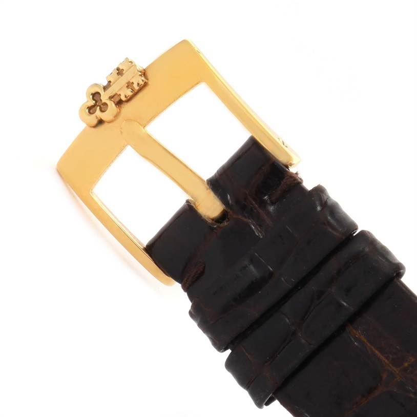 This image shows the gold buckle and part of the leather strap of a Corum Yellow Gold Black Dial Yellow Gold Black Dial 1893 18K Yellow Gold 10 Coin Diamond Watch.