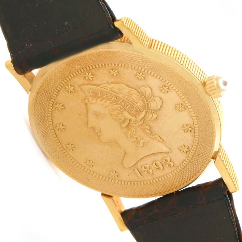 This image shows the back of the Corum Yellow Gold Black Dial Yellow Gold Black Dial 1893 18K Yellow Gold 10 Coin Diamond Watch, highlighting its coin design and strap attachment.