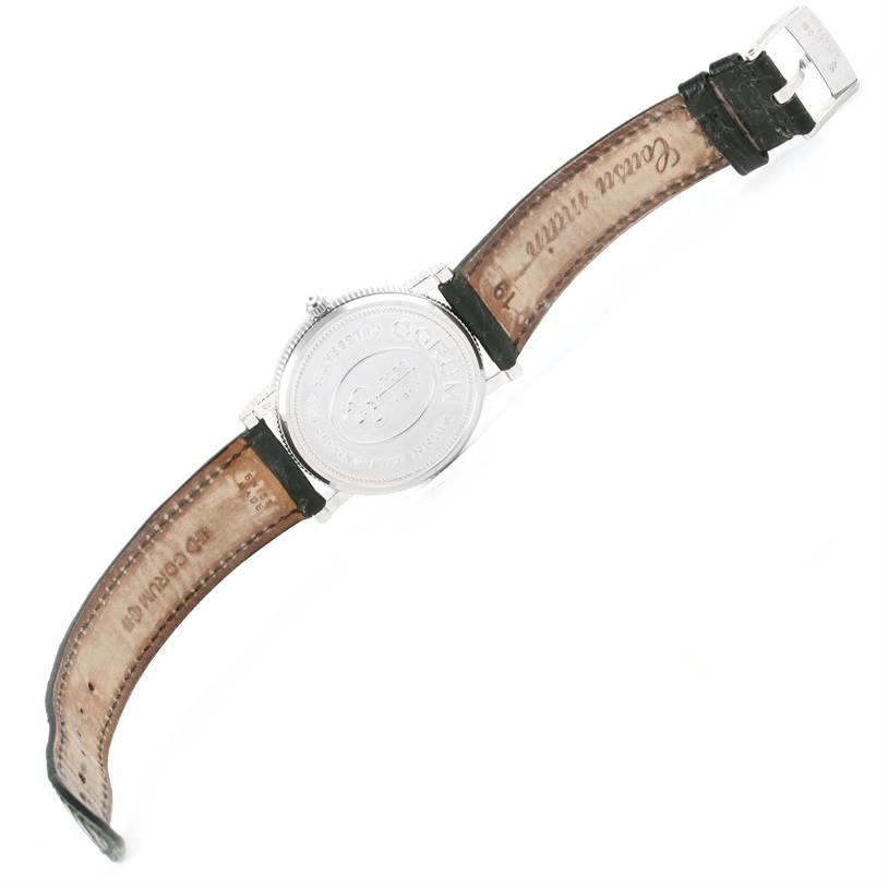 The image shows the back view of a Corum Men's White Gold White Dial Men's White Gold White Dial Celebrates Second Millennium 18K White Gold Automatic LTD Watch, including the strap and buckle.