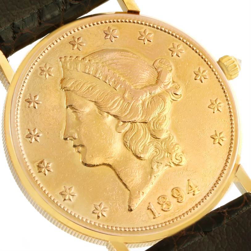 This image shows a close-up of the face and partial strap of the Corum Coin Watch Men's Yellow Gold Black Dial Men's Yellow Gold Black Dial model, highlighting its coin design and crown.