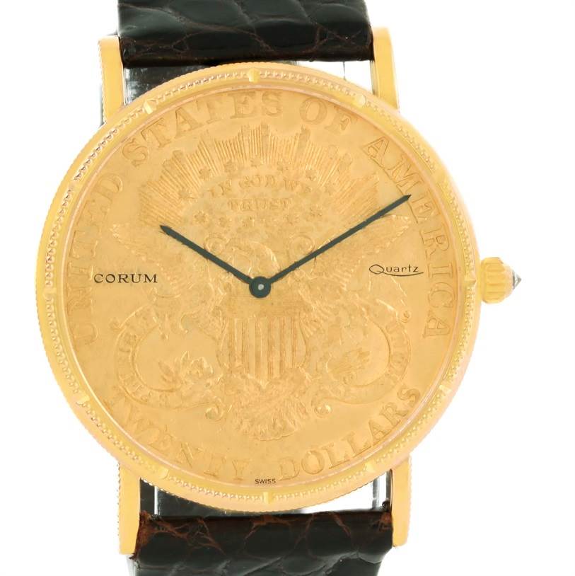 The image shows a front view of the Corum Coin Watch Men's Yellow Gold Black Dial Men's Yellow Gold Black Dial model with a golden dial and black leather strap.