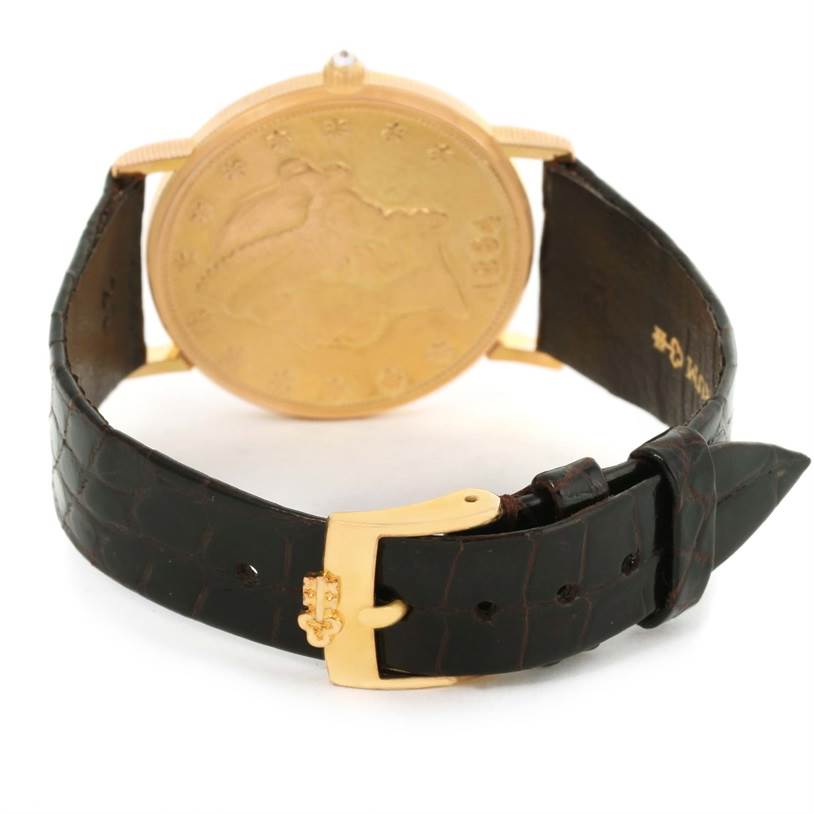 The image shows the backside and strap of the Corum Coin Watch Men's Yellow Gold Black Dial Men's Yellow Gold Black Dial model, showcasing its coin-like back and leather strap.