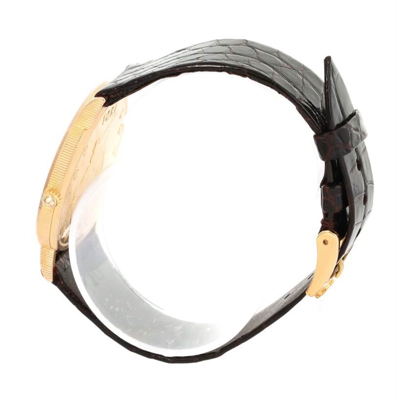 This image shows a side view of the Corum Coin Watch Men's Yellow Gold Black Dial Men's Yellow Gold Black Dial model, highlighting the gold case and black leather strap.