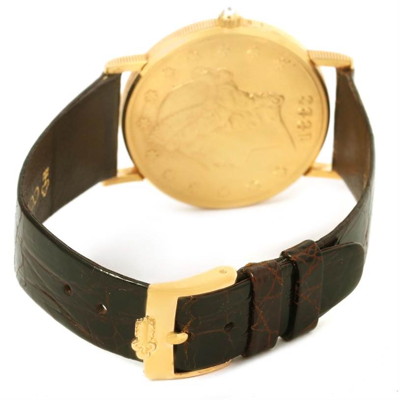 This image shows the back of a Corum Coin Watch Men's Yellow Gold Black Dial Men's Yellow Gold Black Dial model with a focus on the leather strap and gold clasp.