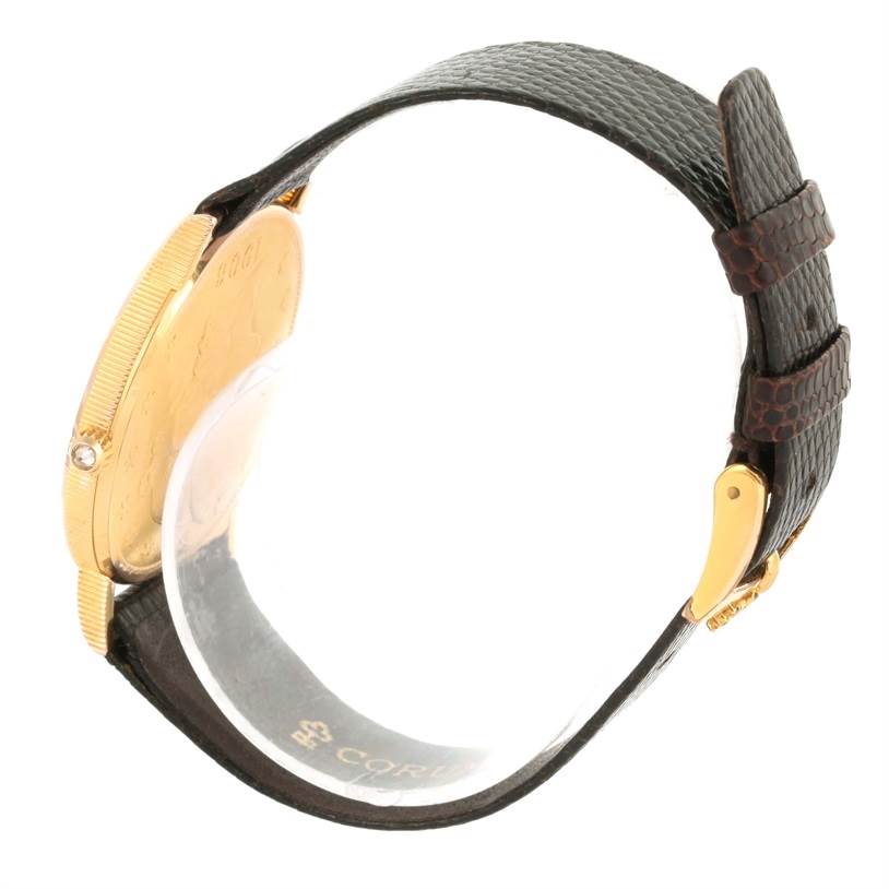 This side view of the Corum Coin Watch Men's Yellow Gold Black Dial Men's Yellow Gold Black Dial model shows the gold case, black leather strap, and buckle.