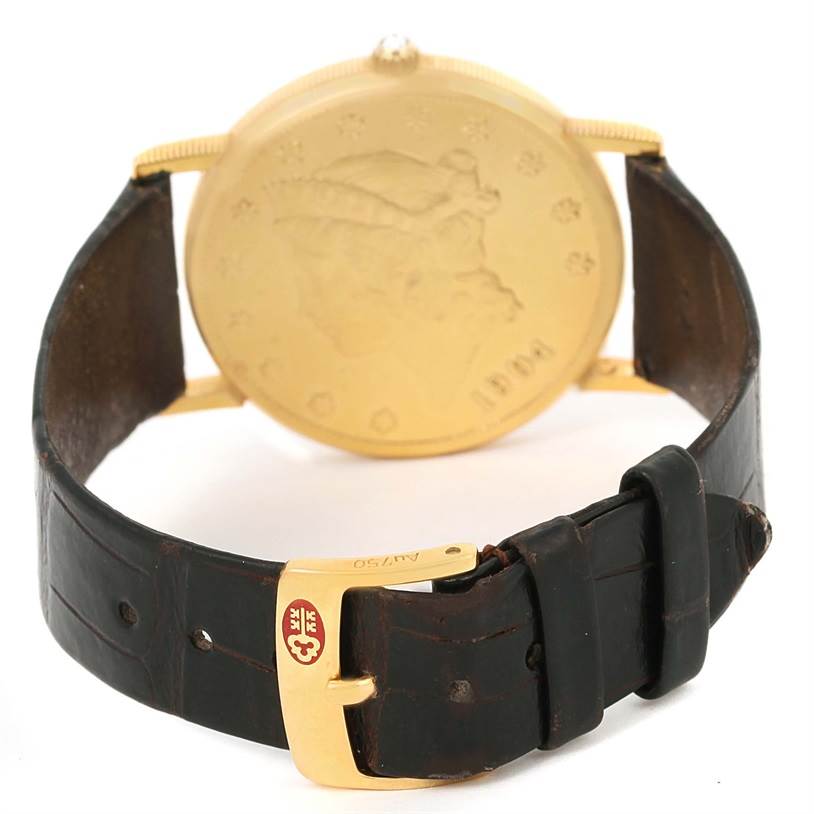 The image shows the back view of a Corum Coin Watch Men's Yellow Gold Black Dial Men's Yellow Gold Black Dial model, highlighting its gold coin face and black leather strap with a gold buckle.